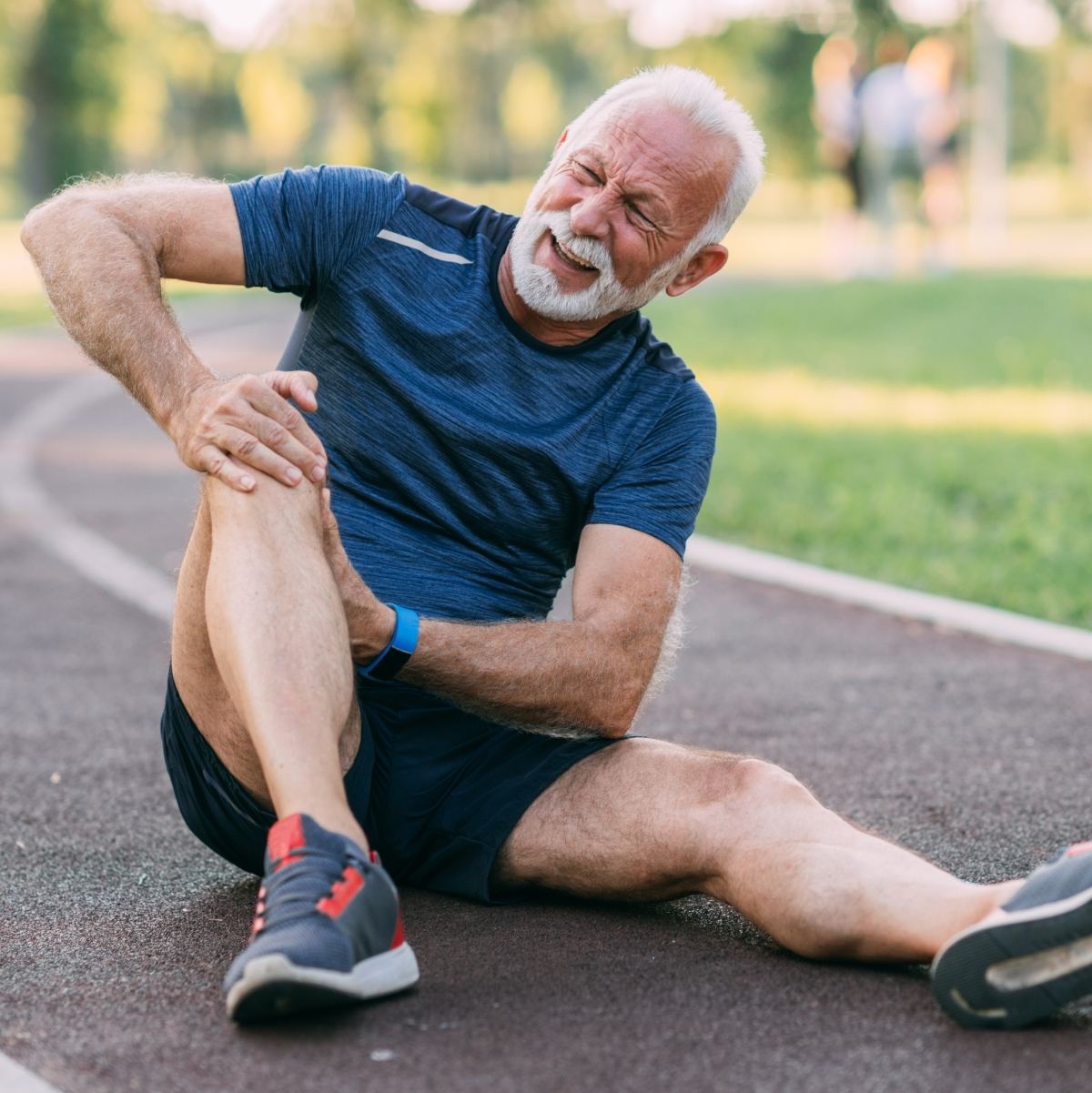 Adulto mayor con dolor de rodilla durante una caminata